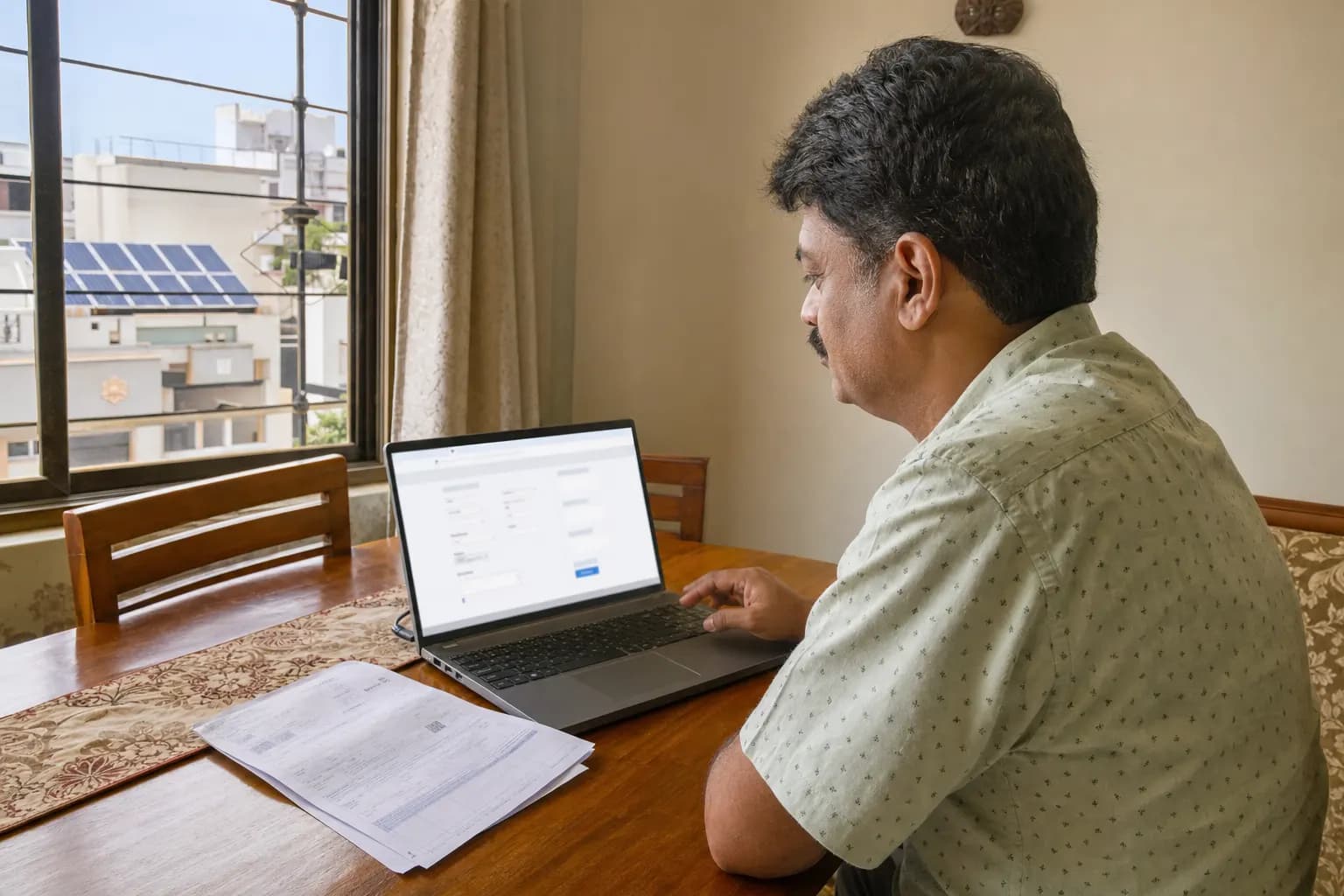 A person viewing a free solar quotation with price, EMI and subsidy details on a laptop screen